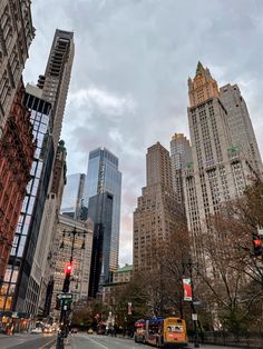 a city street filled with tall buildings and traffic lights next to each other on a cloudy day