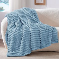 a white couch with a blue blanket on it