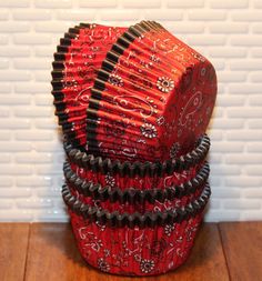 a stack of red and black items sitting on top of a wooden floor