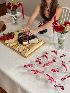 a woman sitting at a table with some food on it and candles in front of her