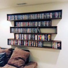 a wall mounted shelf filled with lots of movies