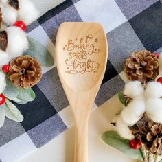 a wooden spoon sitting on top of a table next to cotton balls and pine cones