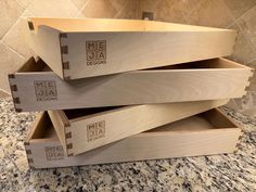 three wooden boxes stacked on top of each other in the middle of a kitchen counter