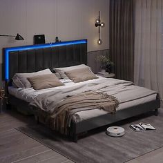 a large bed sitting in a bedroom next to a window with blue lights on it