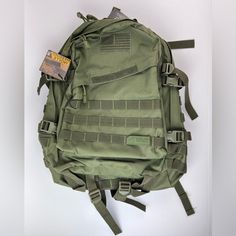 an army green backpack is hanging on the wall