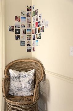 a wicker chair sitting next to a wall with pictures on it