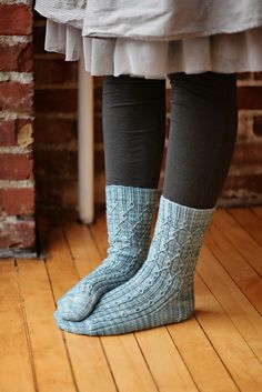 a person standing on a wooden floor wearing socks