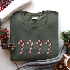 This unisex sweatshirt (we use Gildan) is embroidered with candy canes! * 50% cotton, 50% polyester * Pre-shrunk * Classic fit * 1x1 athletic rib knit collar with spandex * Air-jet spun yarn with a soft feel and reduced pilling * Double-needle stitched collar, shoulders, armholes, cuffs, and hem SIZING: Please ensure you check measurement chart before ordering as shirts are embroidered once you place your order. Sweatshirts are unisex sizes but they fit true to size for ladies. Please size up if you want a roomier fit. If you have any questions about sizing, please feel free to ask! We'd love to help  CARE: Wash inside out in cold water and hang to dry or dry in gentle cycle. Do not iron or if you must, use a towel or pillowcase in between iron and shirt. ORDER PROCESSING AND SHIPPING: You Comfortable Sweater, Sweatshirt Cute, Holiday Shirt, Christmas Embroidery, Christmas Candy Cane, Candy Canes, Cute Christmas