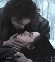 a man and woman in the snow with their hands on each other's shoulders