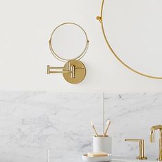 a bathroom with marble counter top and gold faucet on the wall next to it