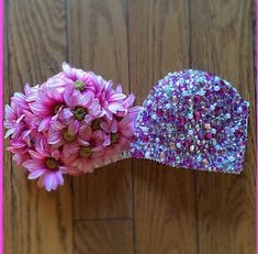 two hats with flowers in them sitting on a wooden floor