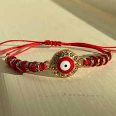 a red bracelet with an evil eye on it