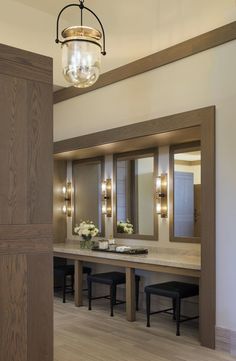 a bathroom with two sinks, mirrors and stools in it's center area