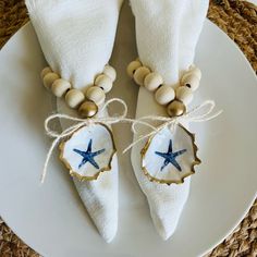 two white napkins with blue starfish decorations on them are sitting on a plate