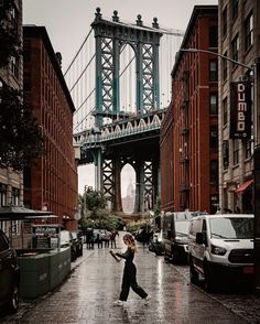 a woman is walking down the street with an umbrella