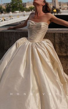 a woman in a wedding dress leaning against a wall