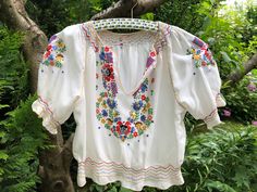 Vintage 40s Hungarian peasant blouse. Silk crepe hand embroidered colorful short sleeve cropped blouse. Traditional Hungarian Matyó floral pattern. The waist and the cuffs are smocked. In excellent vintage condition  To fit XS/S size  Sleeve length from neckline to cuff 12,5" 32cm Bust 41" 104cm Length 17" 43cm White Vintage Peasant Top For Spring, Vintage Embroidered Multicolor Blouse, Vintage White Peasant Top For Festival, White Vintage Peasant Top For Festival, Fitted Vintage Peasant Top For Summer, Retro Embroidered Short Sleeve Blouse, Retro Short Sleeve Embroidered Blouse, Bohemian Fitted Short Sleeve Blouse, Fitted Short Sleeve Bohemian Blouse