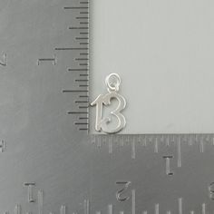 "Number 13 Charm Pendant Details: - Number 13 charm is made of genuine 925 sterling silver - Stamped 925 - Perfect for an anniversary, birthday, or lucky number - Measures approx 15mm x 10mm (5/8\" x 3/8\") - Includes a 5mm jump ring Shipping Details: - All orders are shipped within 1 to 2 business days from California, US - Shipping time frames may become a bit longer as gift-giving holidays approach. Let us know if something is needed by a certain day and we will do our very best to work with Birthday Sterling Silver Charms In Silver, Silver Sterling Silver Charms For Birthday, Birthday Pendant, Number 13, Silver Numbers, Turtle Pendant, Lucky Number, Unique Charms, Cross Pendant