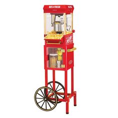 an old fashioned popcorn machine sitting on top of a hard wood floor next to a wall