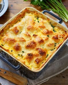 a casserole dish is shown on a table with utensils and plates