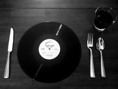 a black and white photo of an empty plate, silverware, and spoons