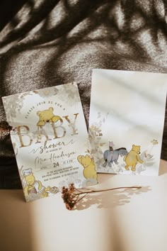 two baby shower items sitting on top of a bed next to each other with winnie the pooh