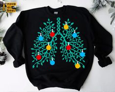 a black sweatshirt with an image of a christmas tree on it and ornaments hanging from the branches