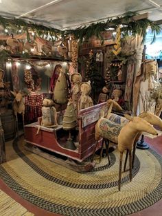 a room filled with lots of christmas decorations and wooden animals on top of rugs