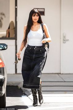 a woman walking down the street with her hand in her pocket