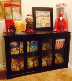 an entertainment center with popcorn, candy and other items on it's sideboard