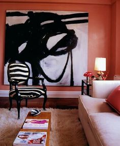 a living room filled with furniture and a painting on the wall