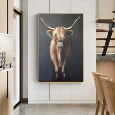 a painting of a cow is hanging on the wall next to a dining room table