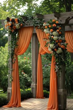 an outdoor wedding ceremony with orange drapes and flowers