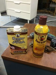 two bottles of liquid sitting on top of a table next to a pair of pliers