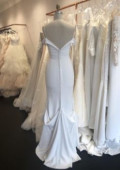 several wedding gowns are on display in a store, with mannequins behind them