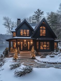 a house is lit up with christmas lights in the front yard and snow on the ground