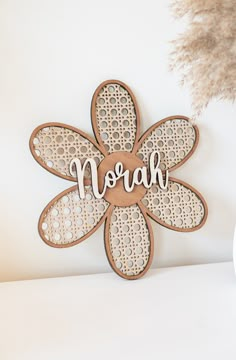 a wooden sign with the word noah written on it next to a potted plant