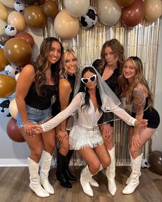 a group of women posing for a photo in front of balloons