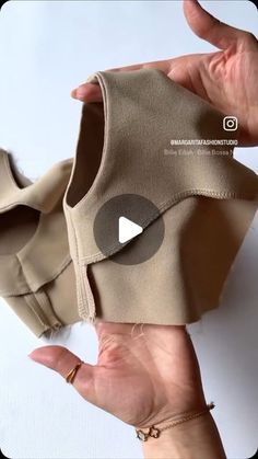 someone is holding up an item that looks like a top with buttons on the front