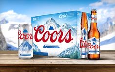 two bottles of beer sitting on top of a wooden table next to an open box