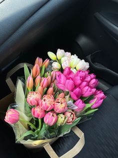 a bouquet of tulips sitting in the passenger seat of a car