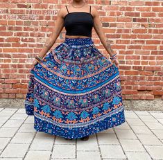 The perfect maxi skirt with pockets  Nice thick material makes it the perfect skirt to twirl in.  Gorgeous blues and oranges with beautiful Indian patterns throughout.  Great for the summer and perfect transition piece for the fall.  Can be worn high waisted or low waisted.  Versatile and fits comfortably with an elastic waist.  Patches include flowers, elephants, mandala prints and more. One size S - L Measurements  Waist 22-44in  Length 37in Lovely cotton material, nice and thick fabric. This Bohemian Tiered Maxi Skirt With Pockets, Bohemian Wide Leg Maxi Skirt With Pockets, Bohemian Maxi Skirt With Pockets, Full-length Summer Festival Skirt, Blue Tiered Maxi Skirt With Pockets, Full Length Summer Festival Skirt, Full Length Skirt For Summer Festival, Bohemian Long Skirt With Pockets, Spring Festival Skirt With Pockets