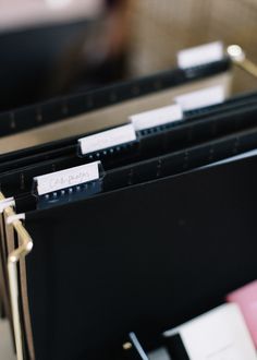 file folders with name tags on them are stacked up in a binder and ready to be used