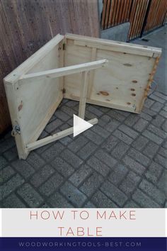 a wooden table sitting on top of a brick floor next to a fence with the words how to make a table