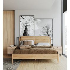 there is a bed with two pictures on the wall