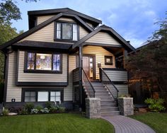 a house with stairs leading up to the front door and side windows on each level