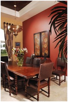 a dining room table with chairs and a vase filled with flowers on top of it