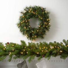 a christmas wreath and stockings on a mantel