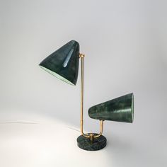 a green lamp sitting on top of a table next to a white wall and floor