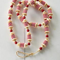 a red and white striped beaded necklace on a string with a wooden cross in the middle